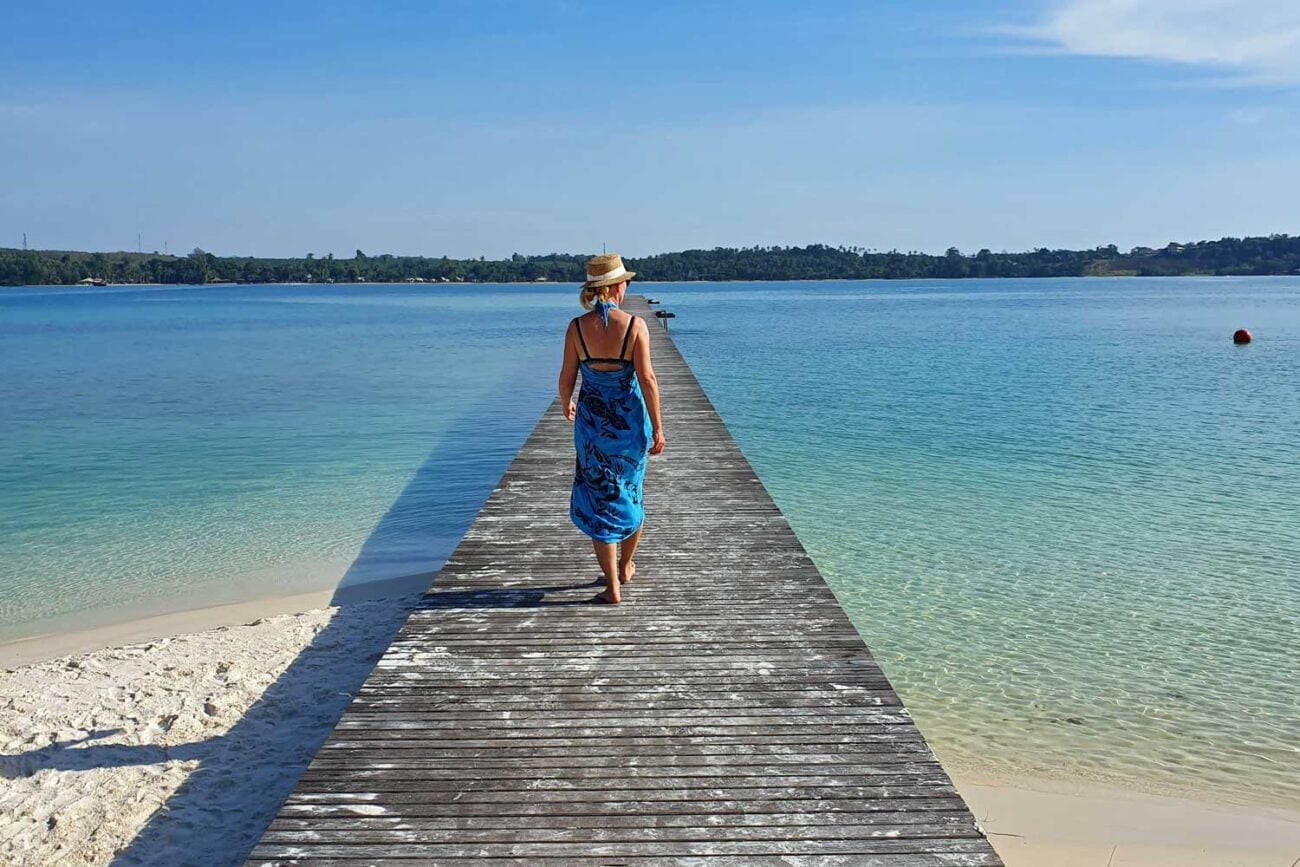 Frau mit Sarong und Sonnenhut auf einem Steg in Thailand