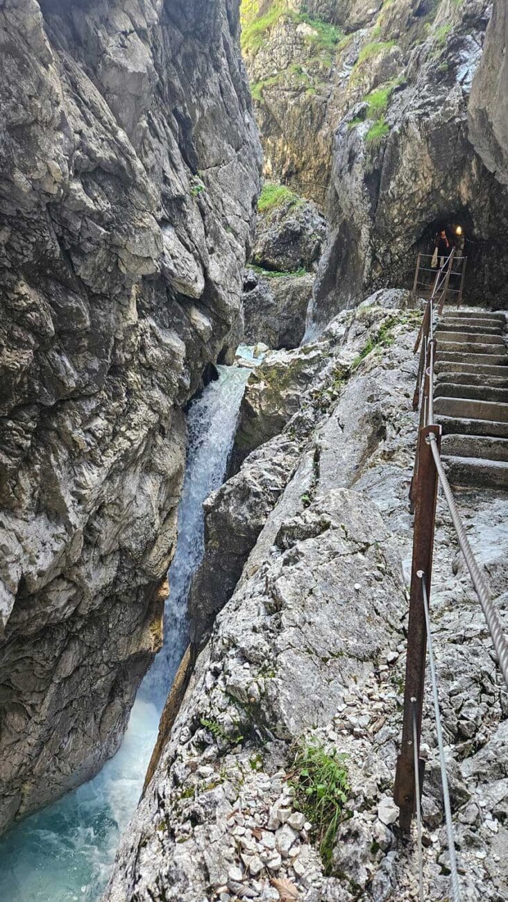 Holzgeländer entlang eines Steges über türkisfarbenem Wasser in der Höllentalklamm