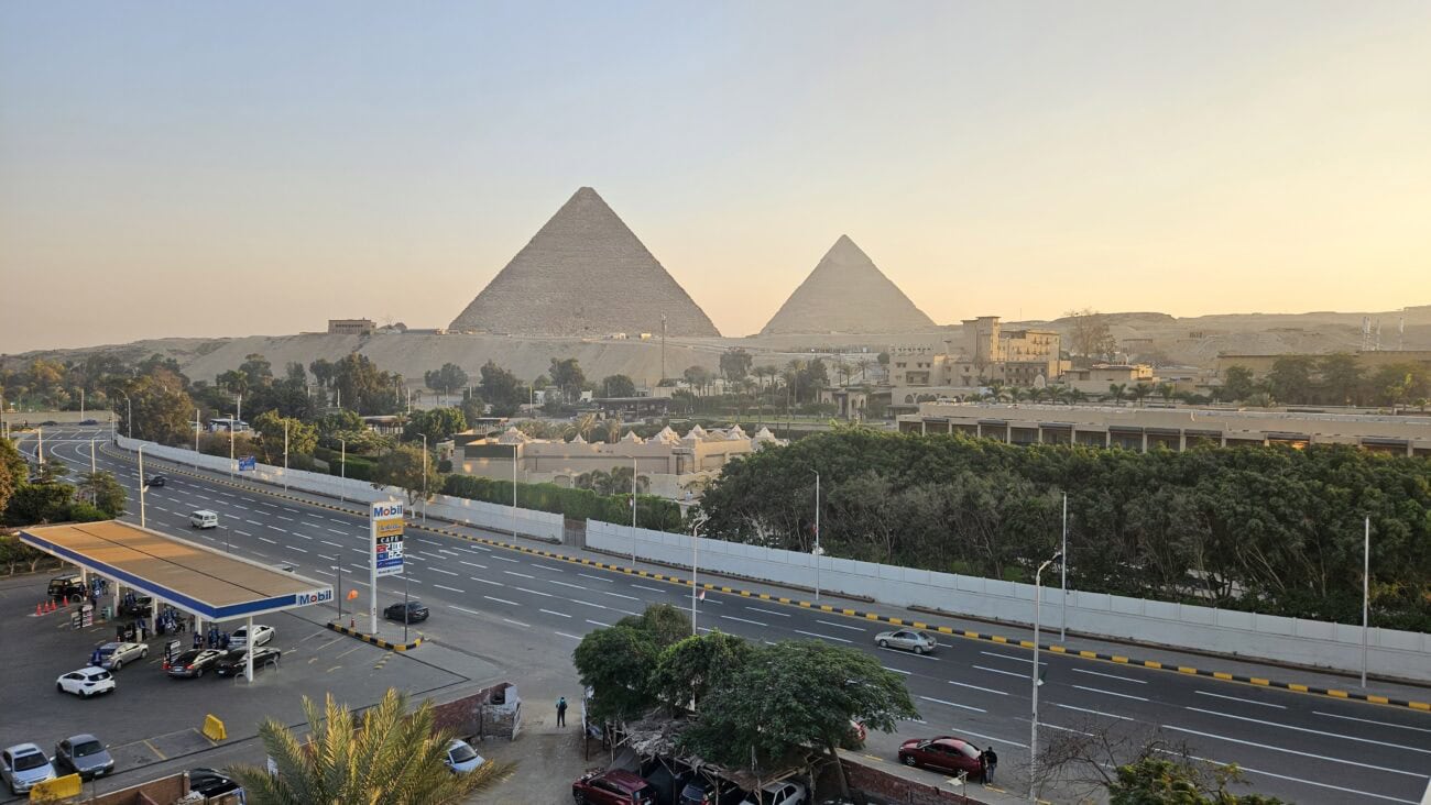 Blick von der Terrasse des Hotel The Kove im fünften Stock auf die Pyramiden von Gizeh bei klarem Tageslicht.