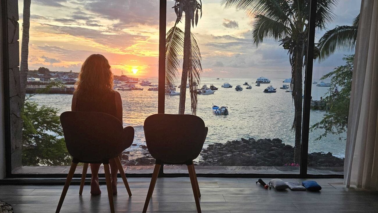 Blick aus einem Zimmer im Golden Bay Galápagos auf Strand und Meer bei Sonnenuntergang.